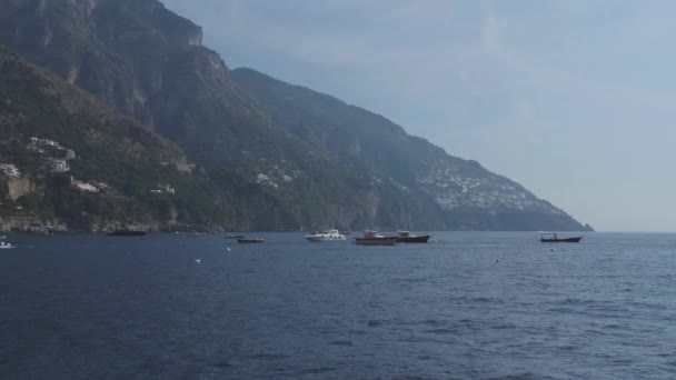 モーター ボートの中で青い海に浮かぶ。起伏のある海岸線の急斜面の町 — ストック動画