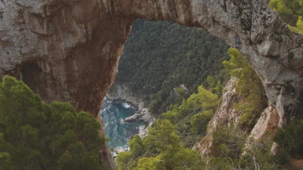 Birds fly over sea shore. View through natural arch on the top of the mountain. Capri, Italy — Stock Video