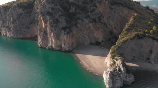 砂浜のビーチは、岩の崖によって閉じ。パリヌーロ、イタリアの海辺の自然なアーチの空中ショット — ストック動画