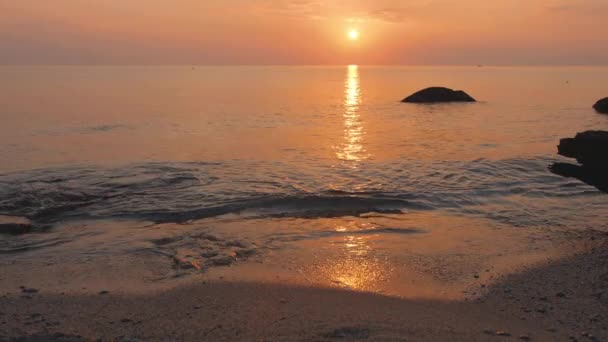 Sonnenuntergang im Meer. Wasser reflektiert Sonnenlicht. Wellen rollen am Sandstrand — Stockvideo