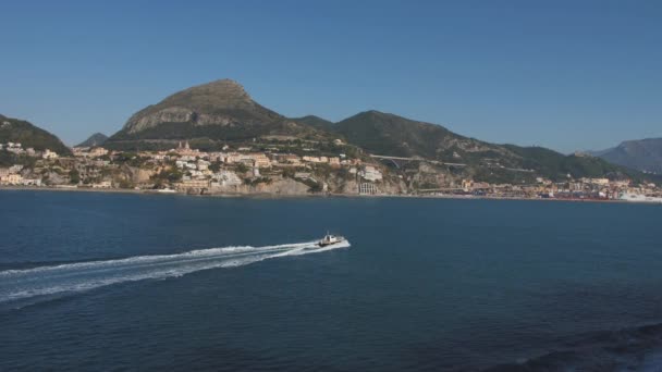 Bateau à moteur flotte le long du littoral montagneux. Journée ensoleillée à Salerne, Italie — Video