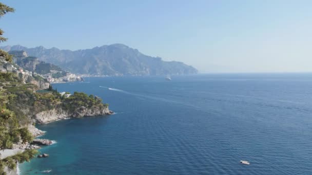 Blå havet och bergiga shore. Små båtar under den kustnära klippan. Amalfikusten, Italien — Stockvideo