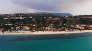 Kara bulut mavi deniz ve kıyı otel ve tatil binalar üzerinde. Hava atışı