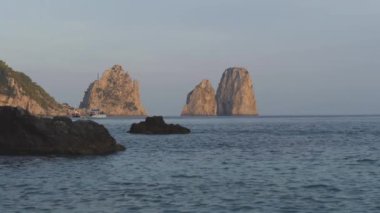 Gün batımında bağlantılı yelken tekne agains Faraglioni deniz yığını. Capri, İtalya