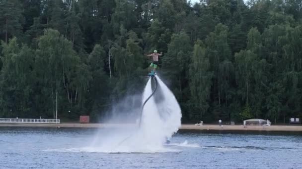 Человек на флайборде крутится над поверхностью воды — стоковое видео