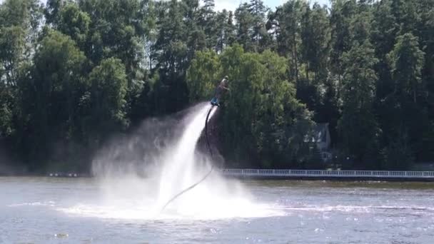 Cavaliere Flyboard volare sopra l'acqua filatura in spruzzi — Video Stock