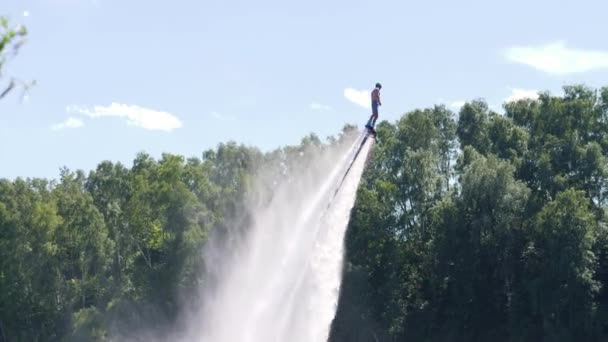 L'uomo vola sul flyboard e cade in acqua attraverso spruzzi — Video Stock