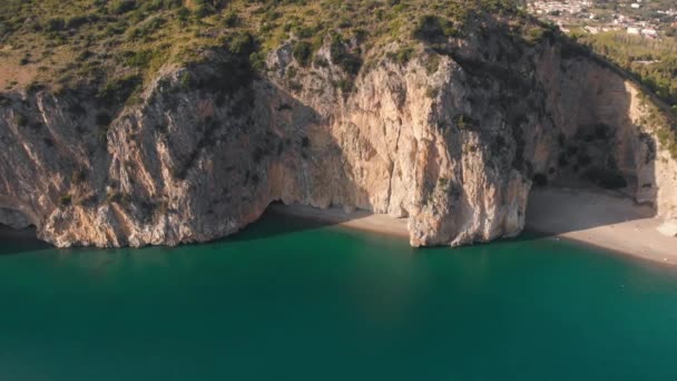 Fliegen von den steilen Felsen über dem türkisfarbenen Wasser des Meeres weg. Luftaufnahme der italienischen Küste in Palinuro. — Stockvideo