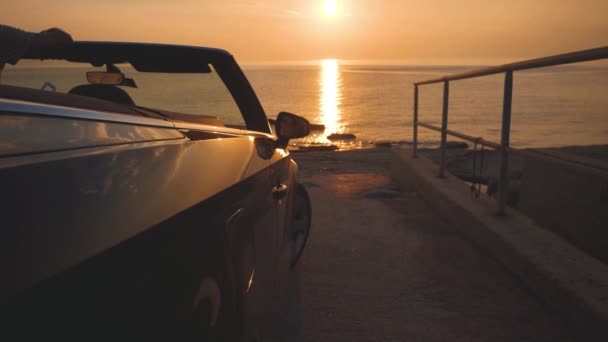 Άνθρωπος Μοιάζει Ηλιοβασίλεμα Πάνω Από Θάλασσα Μαύρο Αυτοκίνητο Ανοικτή Κορυφή — Αρχείο Βίντεο