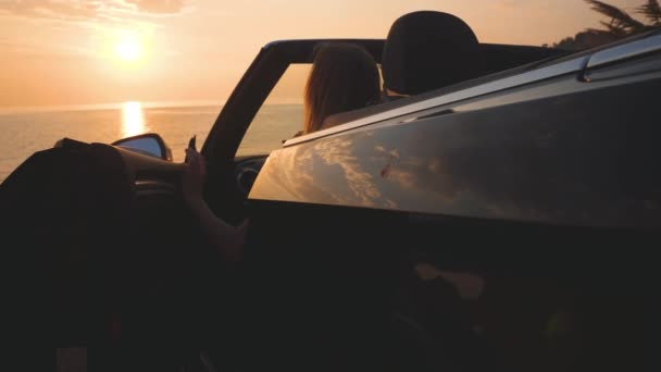 Chica bonita en vestido sale de coche de lujo y corre hacia el mar y el cielo puesta de sol — Vídeos de Stock