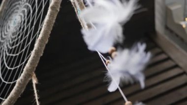 Boncuklu ve tüylü bir düş kapanı. Tılsımın asılmasına az kaldı. Düşük açılı çekim