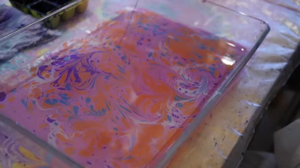 Dünne Sticks kleben bunte Tinten auf die Wasseroberfläche. ebru art in blauer Farbe — Stockvideo