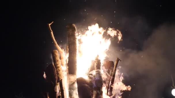 火の炎と大きなキャンプファイヤーの煙が暗い夜空に行きます。ローアングルショット — ストック動画