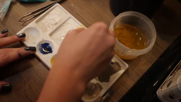 Жінка поєднує в собі рукотворні фарби. Кольори солодкої їжі в білій палітрі — стокове відео