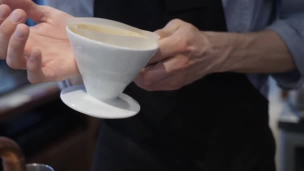 Бариста струшує фільтр, наповнений ароматом меленої кави. Оформлення ранкового напою — стокове відео