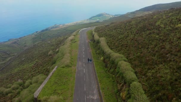 Nesli tükenmiş yeşil volkan yamacından okyanusa doğru ilerleyen çift. Corvo, Azores 'in hava görüntüsü. — Stok video