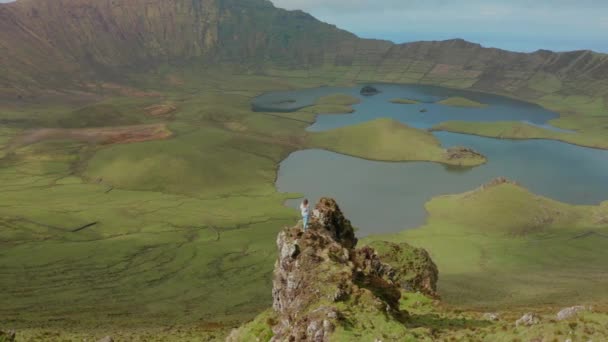 妇女在岩石边缘的巨大火山口之上活跃的平流层。 Caldeirao 、 Corvo 、 Azores的空中 — 图库视频影像