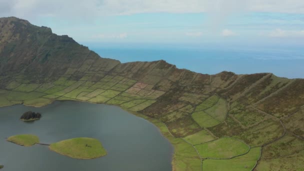 Lecąc w kierunku końca świata. Zielone zbocze kaldery i oceanu za vlocano. Zdjęcie Corvo, Azory — Wideo stockowe