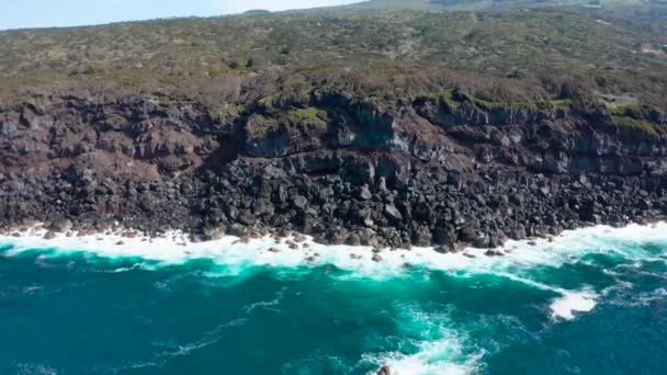 Moviéndose a lo largo del acantilado rocoso sobre el océano azul. Lento movimiento de surf. Aérea de Faial, Azores — Vídeos de Stock