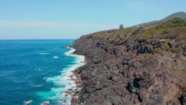 Fliegen entlang der Küste mit Felsen und großen schwarzen Steinen. Antenne von Küste und blauen Wellen — Stockvideo