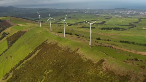 Wieże wiatrowe z obrotowymi ostrzami na wzgórzu w zielonej dolinie Serra do Cumo. Przestrzeń powietrzna Terceira, Azory — Wideo stockowe