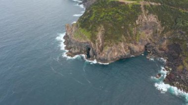 Deniz kıyısındaki uçurum. Rocku dağındaki yeşil bitkiler. Terceira adası, Azores.
