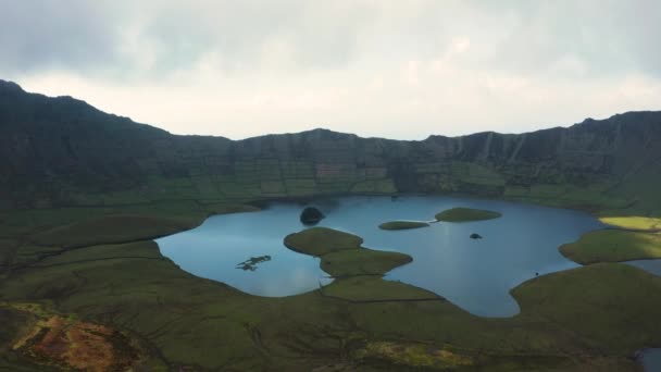 Lago poco profundo al pie de la montaña. Cielo nublado sobre la caldera del volcán. Corvo, Azores — Vídeos de Stock