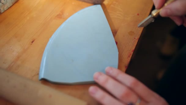 Kvinnliga händer noggrant skära bit av keramik med glas cutter. Närbild — Stockvideo