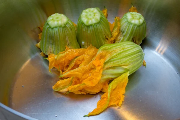 Cooking stuffed zucchini flowers / squash blossom - an Italian and Greek delicacy stuffed with rice, tomato, and herbs