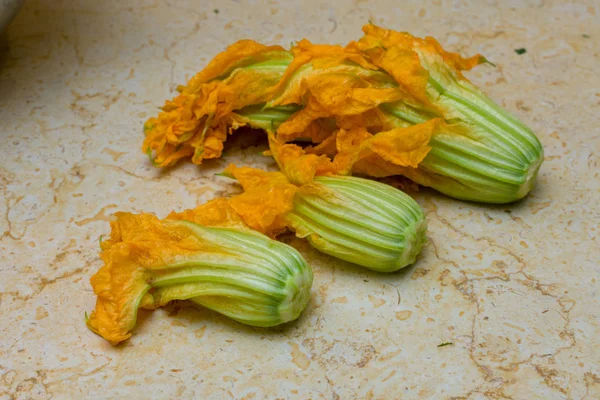 Cooking stuffed zucchini flowers / squash blossom - an Italian and Greek delicacy stuffed with rice, tomato, and herbs