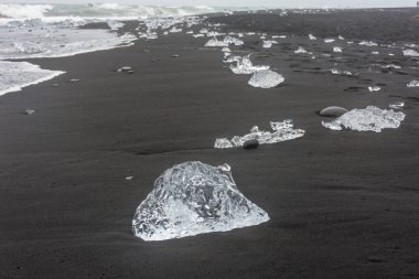 Beach plaj ve güzel kontrastlı siyah kum denize Jokulsarlon Glaciar lagün çalışır buz nerede yıkanmış South Iceland'deki / daki elmas