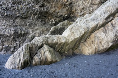 Şaşırtıcı tek sıra halinde bazalt oluşumları, tonozlu bir covern ve deniz kaya yığınları görünür plaja ses İzlanda'daki Reynisfjara siyah kum plaj