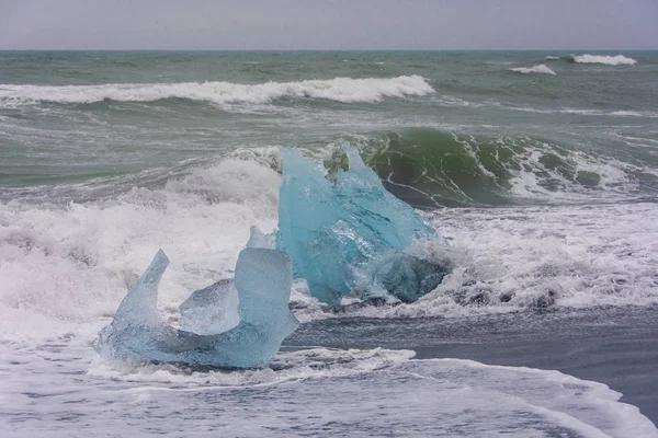 在冰岛南部的钻石海滩 那里的冰从 Jokulsarlon Glaciar 泻湖向大海冲回海滩 并与黑沙形成鲜明对比 — 图库照片