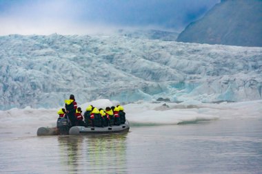 Vatnajokull, İzlanda - 28 Temmuz 201: South Iceland'deki / daki Fjallsarlon buzul lagün bir kol büyük Vatnajokull buzulun üzerinde mavi buz zodyak bot Turu üzerinde yelken iki aile