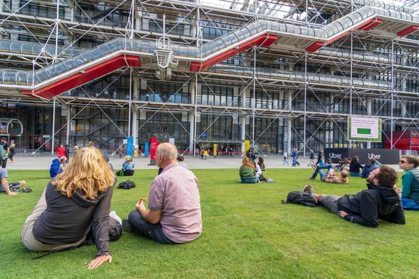Emberek a fűben a Pompidou központ múzeumán kívül, Párizs — Stock Fotó