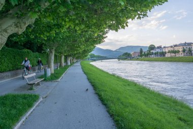 İnsanlar bisiklet ve Salbach nehri yakınında