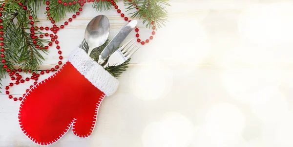 Julfana.Idén att förpacka julklappar med en vante, Bestick: en sked, kniv och gaffel med julgransgrenar. Vit trä bakgrund, röda pärlor, bokke — Stockfoto