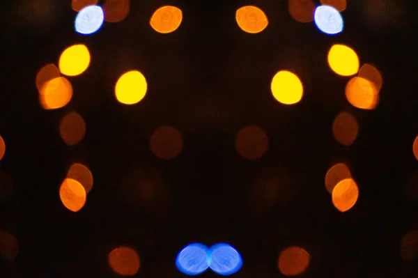 Disposessory Christmas multicolored background. Abstract blurry bokeh of red, yellow, blue, and white on a black background