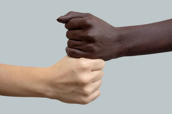 拳の形をした黒と白の手は 互いの上に置かれます 灰色の隔離された背景 人種間の友情と尊敬の概念 人種差別との戦い — ストック写真