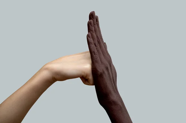 Δύο Χέρια Ασπρόμαυρα Μια Λευκή Γροθιά Χτυπά Μια Μαύρη Παλάμη — Φωτογραφία Αρχείου