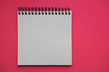 Kırmızı zemin üzerinde Kraft kağıdı yaprakları izole boş bir Notepad fotoğraf. Yüksek çözünürlük