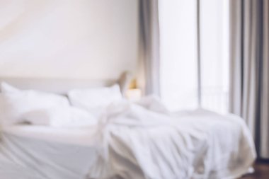 Güneş ışığı, dağınık yatak çarşafları ve yorgan ile kırışıklık dağınık yatak odasında bulanık konforlu yatak odası