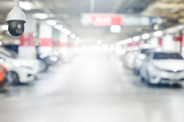 Cctv security camera on blur underground cars parking garage with light on exit way use as background — Stock Photo, Image