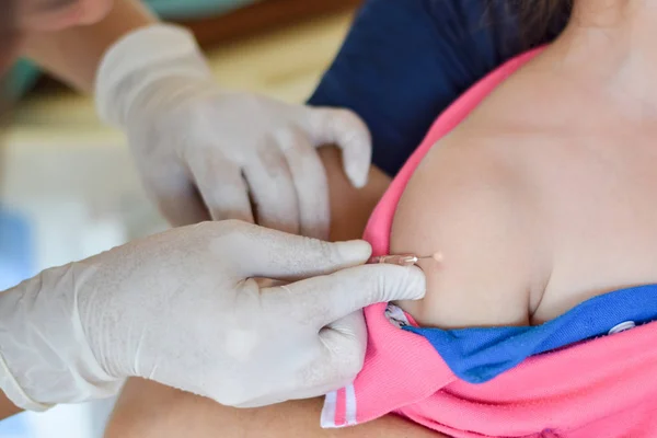 Enfermero médico que administra la vacuna inyectable con jeringa en brazos del niño, con los padres sosteniendo al niño, no se mueva mientras se inyecta la vacuna de preexposición — Foto de Stock