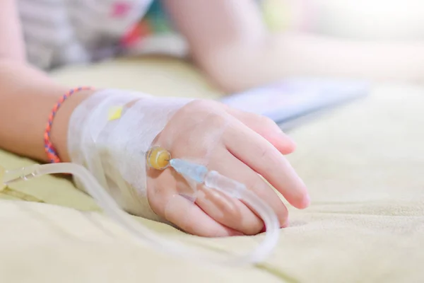IV solution in a childs patients hand,Close up Children patients hand recieving iv saline solution in hostpital — Stock Photo, Image