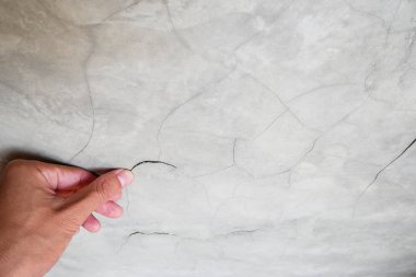 Ev yapımında beton çatlak duvara işaret eden el parmağı sorunları ve çözüm konsepti