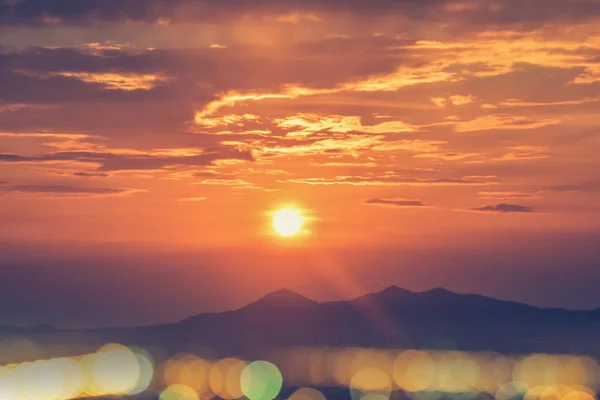 Sonnenaufgang über den Bergen mit Bokeh-Lichtern aus der Stadt — Stockfoto