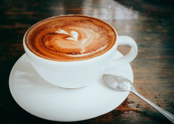 Arte latte café caliente sobre fondo de tabla de madera de cerca —  Fotos de Stock