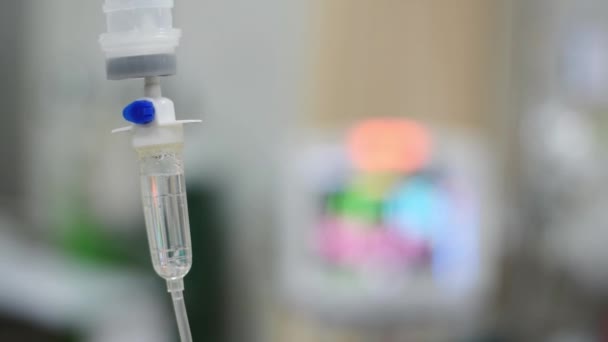 IV infusieset en fles op een paal. Vloeibare zoutoplossing druppelt langzaam druppels drugs, geneeskunde of antibioticumtherapie en chirurgie herstel in een ziekenhuis of kliniek — Stockvideo