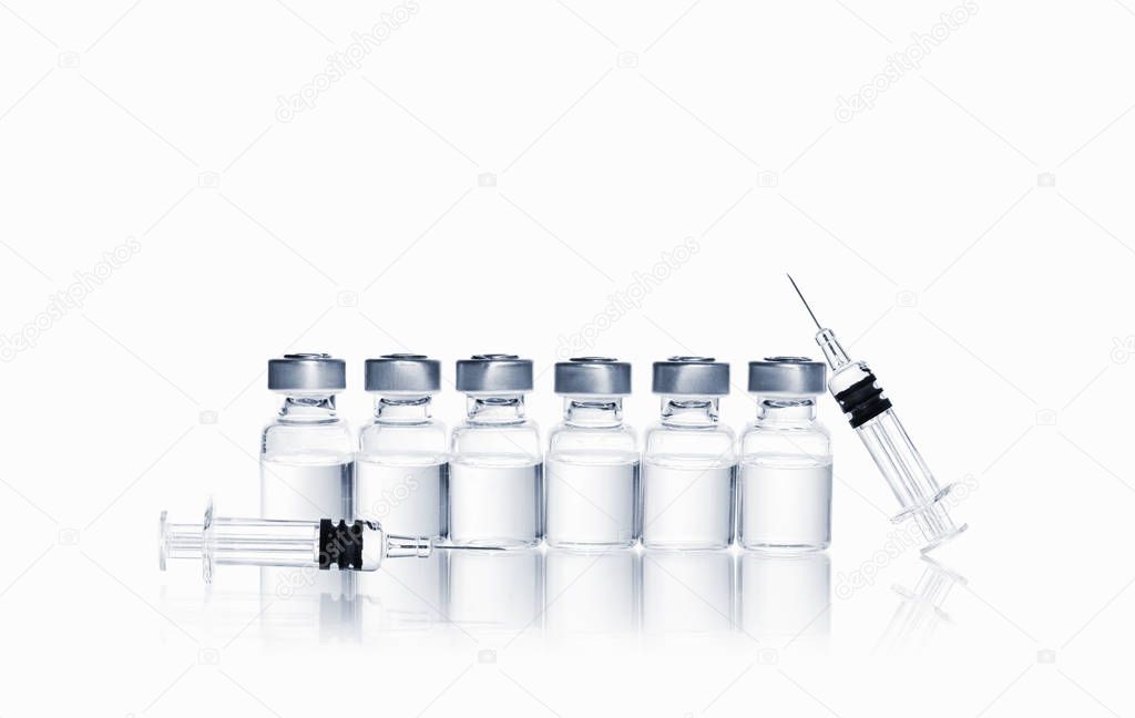 row of vials with medication and syringe with needle for injection on white background